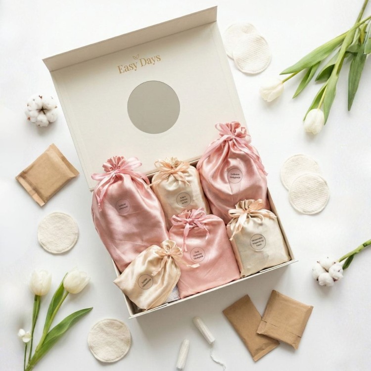 Otwarty Easy Days Box Troska w otoczeniu białych tulipanów. Estetyczny i delikatny prezent dla córki na rozpoczęcie miesiączkowania.